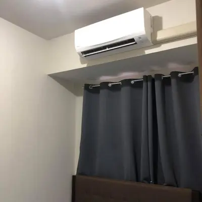 a room with a curtain and a air conditioner at S Residence Condo Near MOA,IKEA in Manila