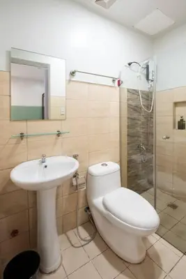 a bathroom with a toilet and a sink and a shower at St. Marvin Studio Makati M407 in Manila
