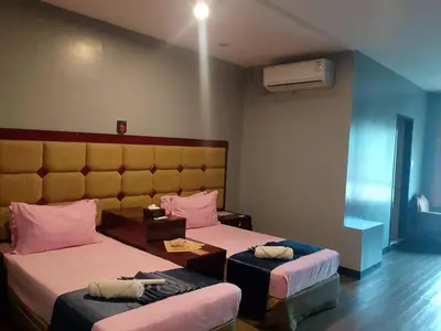 a hotel room with two beds and a table at Jjimjbang hotel spa in Manila