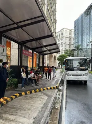 a bus stopped at a bus stop on a city street at Airport NAIA Terminal 3 Insane Interior in Manila