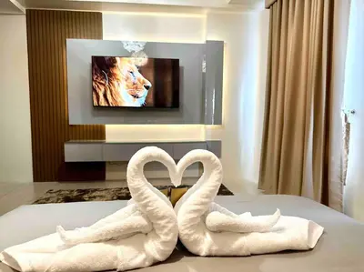 two towel swans sitting on a bed in front of a tv at Airport NAIA Terminal 3 Insane Interior in Manila