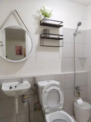 a bathroom with a sink and a toilet and a mirror at 2BR Condo by Coco's Haven in Manila