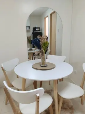a white table and chairs with a vase on it at 2BR Condo by Coco's Haven in Manila