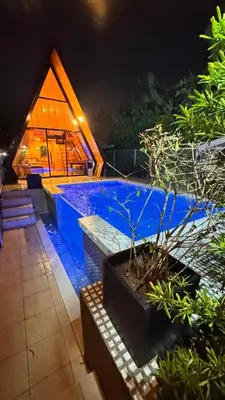 a swimming pool with a house in the background at night at CD NATUREVIEW in Matangtubig