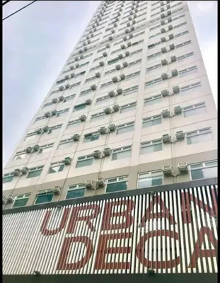 a tall white building with a sign in front of it at Modern style Condo with Unli Wifi and Netflix in Manila
