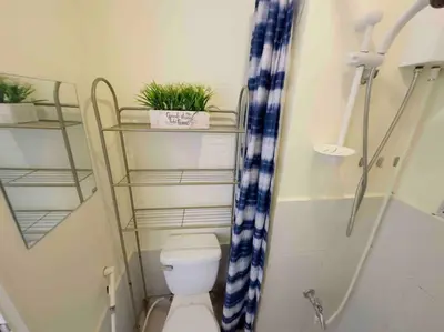 a small bathroom with a toilet and a shower at Modern style Condo with Unli Wifi and Netflix in Manila