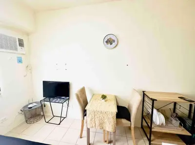 a room with a table and chairs and a clock on the wall at Modern style Condo with Unli Wifi and Netflix in Manila