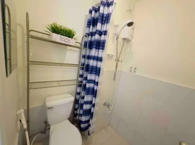 a bathroom with a toilet and a shower curtain at Modern style Condo with Unli Wifi and Netflix in Manila