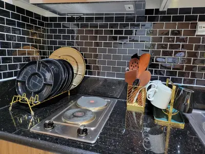 a kitchen counter with a fan and a sink at SHORE 3 TOWER 1 Mall of Asia- Casa Sandique in Manila