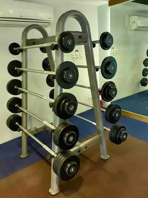 a rack filled with dumbbells in a gym at Modern 1BR apartment in Manila