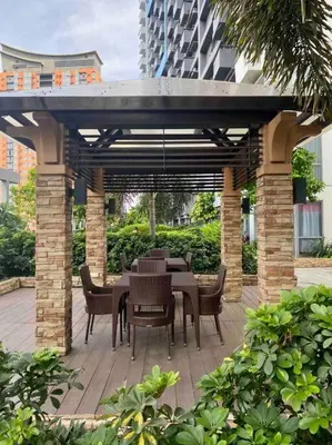 a patio with a table and chairs under a pavilion at Modern 1BR apartment in Manila
