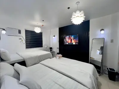 a hotel room with three beds and a tv at Staycation Condotel Room to Stay Paranaque in Manila