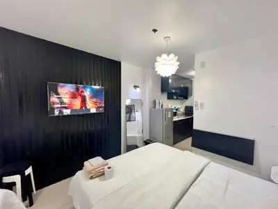 a bedroom with a bed and a tv on a wall at Staycation Condotel Room to Stay Paranaque in Manila