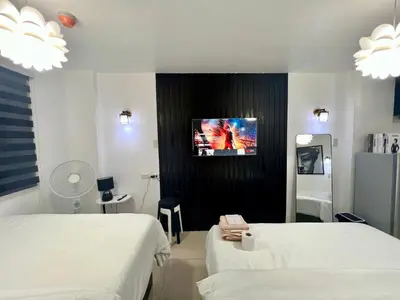 a hospital room with two beds and a tv on the wall at Staycation Condotel Room to Stay Paranaque in Manila