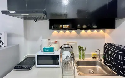 a kitchen counter with a sink and a microwave at Staycation Condotel Room to Stay Paranaque in Manila