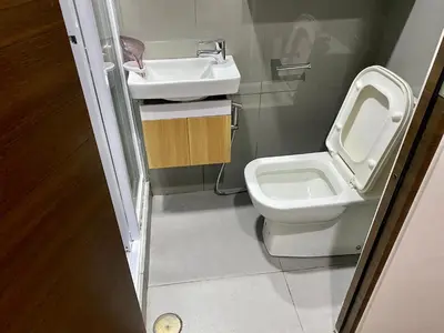 a small bathroom with a toilet and a sink at Woodland Elegance Retreat Symphony of Artistry with Blazing fast 300 Mbps in Manila