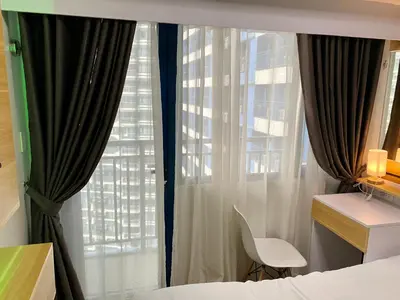 a bedroom with a bed and a window with curtains at Woodland Elegance Retreat Symphony of Artistry with Blazing fast 300 Mbps in Manila
