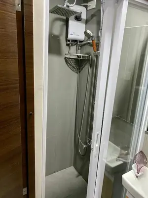 a shower with a shower head in a bathroom at Woodland Elegance Retreat Symphony of Artistry with Blazing fast 300 Mbps in Manila