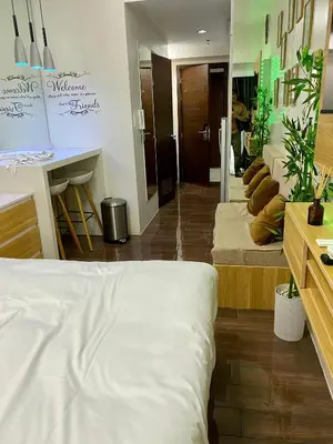 a bedroom with a white bed and a room with tables at Woodland Elegance Retreat Symphony of Artistry with Blazing fast 300 Mbps in Manila