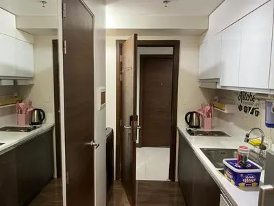a kitchen with white cabinets and a door to a sink at Woodland Elegance Retreat Symphony of Artistry with Blazing fast 300 Mbps in Manila