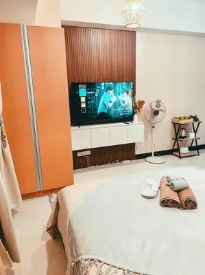 a bedroom with a tv and a bed with shoes at Condo Unit Viceroy Residences Mckinley Hill cd22b in Manila