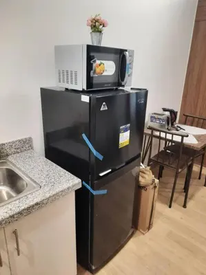 a microwave on top of a refrigerator in a kitchen at SMDC Spring Malachai's place in Manila