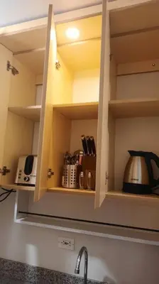 a kitchen cupboard with a coffee maker and a tea kettle at SMDC Spring Malachai's place in Manila