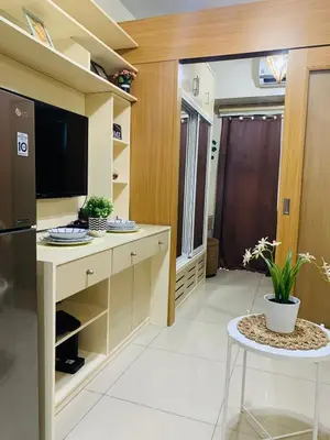 a kitchen with a tv and a table in a room at Aiza's CondoTel in Shell Residences near MOA and NAIA in Manila