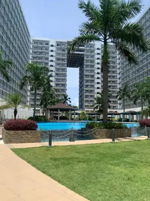 a swimming pool in a park with tall buildings at Aiza's CondoTel in Shell Residences near MOA and NAIA in Manila