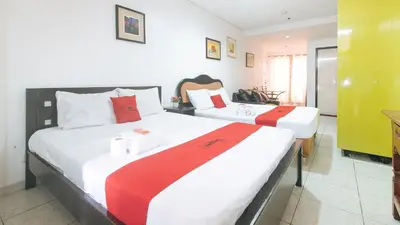 a bedroom with two beds with red and white sheets at RedDoorz at TJMG by Bel Air Polaris Makati in Manila
