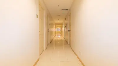 an empty hallway with a long white corridor at RedDoorz at TJMG by Bel Air Polaris Makati in Manila