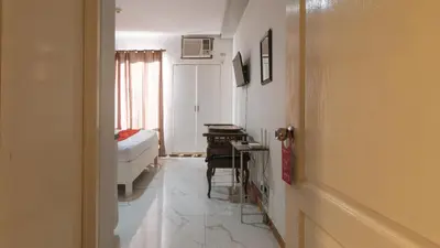 a bedroom with a bed and a desk in a room at RedDoorz at TJMG by Bel Air Polaris Makati in Manila