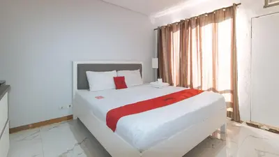 a white bed in a white room with a window at RedDoorz at TJMG by Bel Air Polaris Makati in Manila