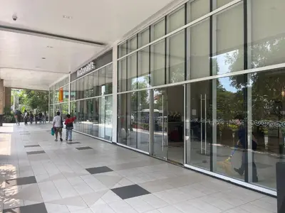 a large glass building with people walking in front of it at 150 Newport Boulevard, near Terminal3 Airport in Manila