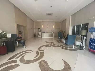 a man sitting in a lobby with a carpet on the floor at 150 Newport Boulevard, near Terminal3 Airport in Manila