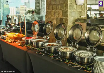 a buffet with many pots and pans on a table at City Garden Grand Hotel in Manila