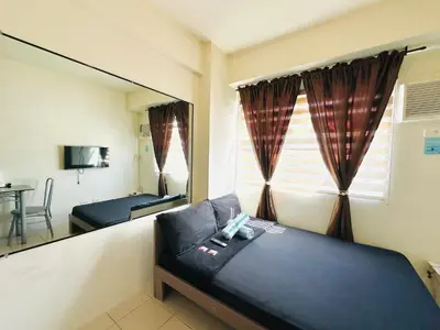 a room with a bed and a large mirror at Fancy Condo with Unli Wifi and Netflix in Manila