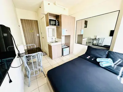 a small apartment with a large blue bed in a room at Fancy Condo with Unli Wifi and Netflix in Manila