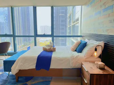 a bedroom with a large bed and a large window at MODERN BGC 1BR, Uptown Mall Connector, 5G WiFi, Pool, Ste 17 in Manila