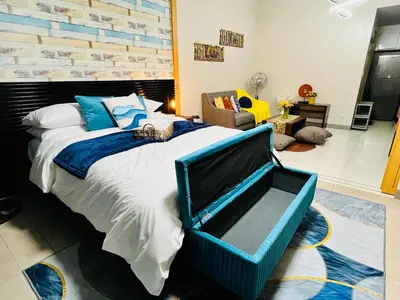 a bedroom with a large bed and a chair at MODERN BGC 1BR, Uptown Mall Connector, 5G WiFi, Pool, Ste 17 in Manila