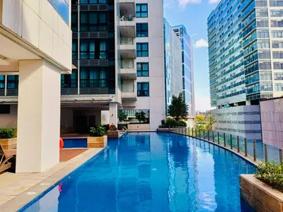a swimming pool in a building with tall buildings at MODERN BGC 1BR, Uptown Mall Connector, 5G WiFi, Pool, Ste 17 in Manila