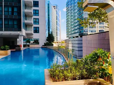 a swimming pool in a building with tall buildings at HUGE 2BR BGC Suite 70sqm, Perfect for 6, Balcony, Pool & Uptown Mall Connector, Ste 25 in Manila