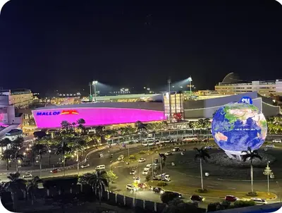 a city with a large building with a world projected on it at PinkDoorZ MOA Staycation at SEA Residences in Manila