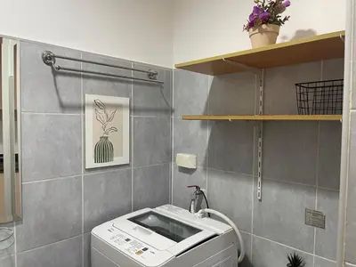 a bathroom with a washing machine and a toilet at PinkDoorZ MOA Staycation at SEA Residences in Manila