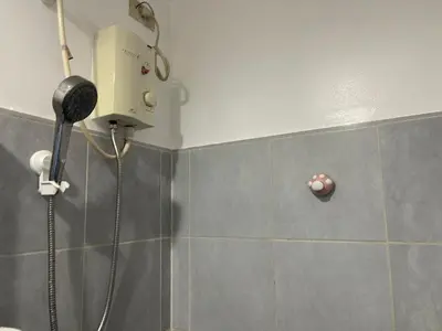 a shower with a blow dryer in a bathroom at PinkDoorZ MOA Staycation at SEA Residences in Manila