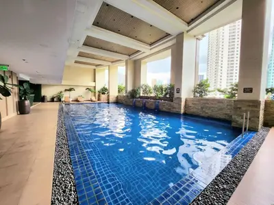 a large swimming pool in a hotel lobby at KL Tower Cosy Studio with Balcony Sauna Gym Pool near Greenbelt in Manila