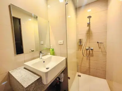 a bathroom with a sink and a shower at BGC Cosy Spacious 1BR Uptown Parksuites with Balcony in Manila