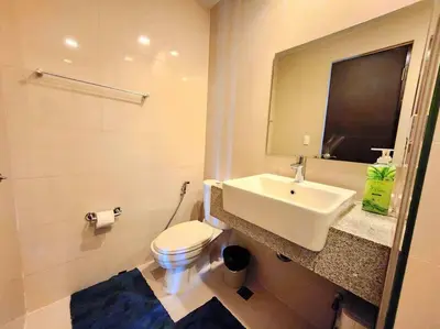a white bathroom with a sink and a toilet at BGC Cosy Spacious 1BR Uptown Parksuites with Balcony in Manila