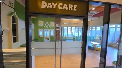 a day care sign on the door of a building at Cosy BGC Uptown Parksuites with Nice Balcony City View and Ultra Fast Internet 300mbps in Manila