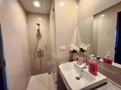 a bathroom with a shower and a sink and a mirror at Cosy BGC Uptown Parksuites with Nice Balcony City View and Ultra Fast Internet 300mbps in Manila